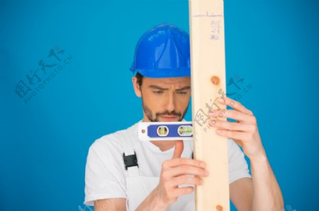 在测量木板的建筑工程师图片