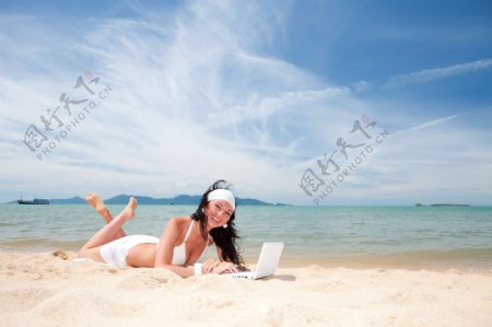 趴在沙滩上上网的时尚美女图片图片