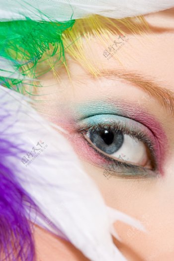 女人脸颊旁的彩色羽毛图片图片