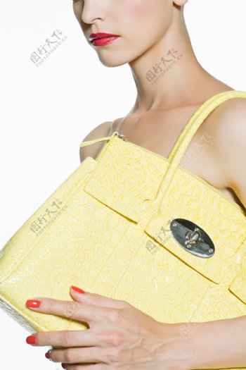 挎黄色时尚皮包的女人图片