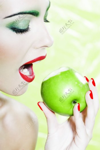 拿着青苹果咬的女人图片