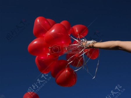 手中拿着红色心型的气球
