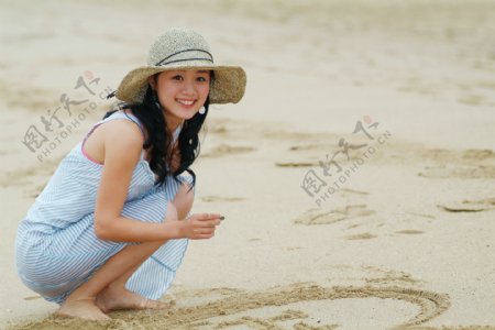 在沙滩上画写的美女图片