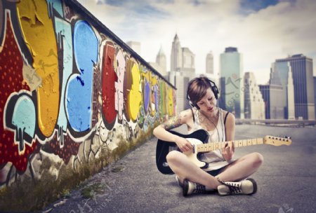 坐在地面弹吉他的时尚美女图片
