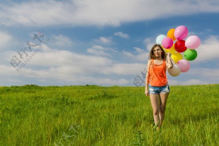 草地上拿气球的美女图片
