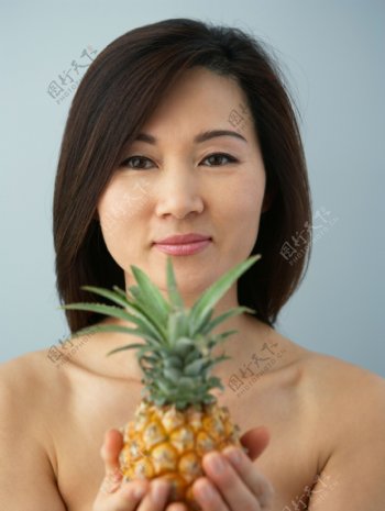手捧菠萝的女性图片