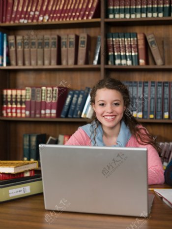图书馆笔记本电脑前微笑的女孩图片