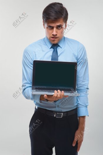 抱着笔记本电脑的职业男士图片