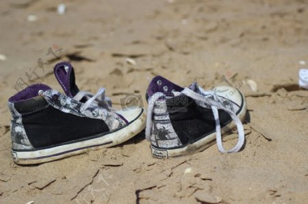 放在沙滩上面的鞋子