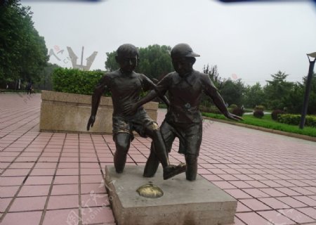 两个小孩玩足球雕塑